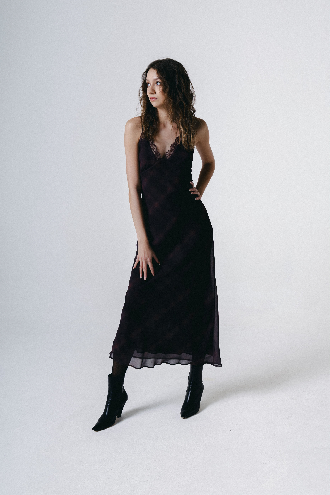 Full-length in a plum slip dress and black boots